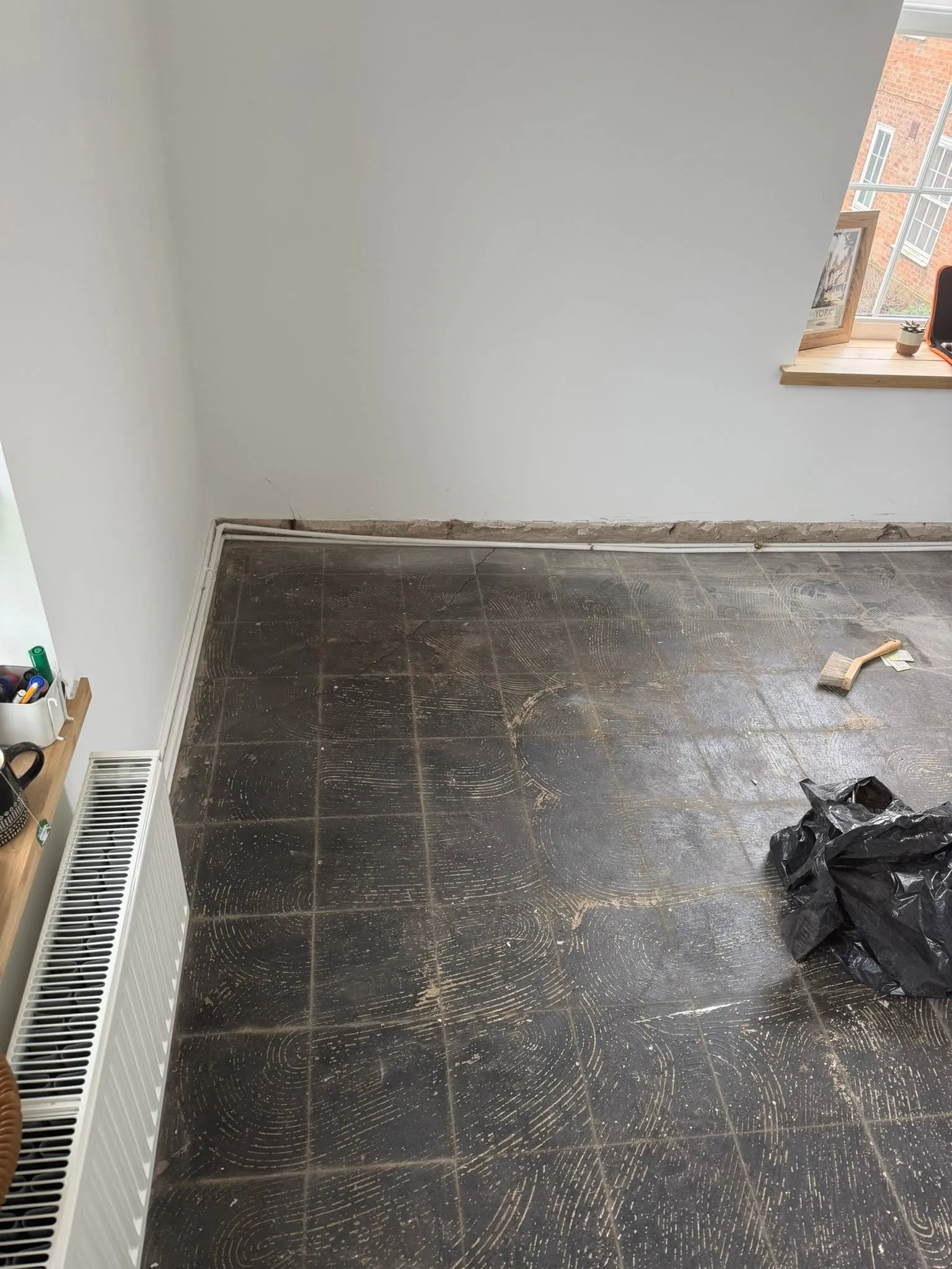 Part-assembled white bed frame on a newly laid laminate floor