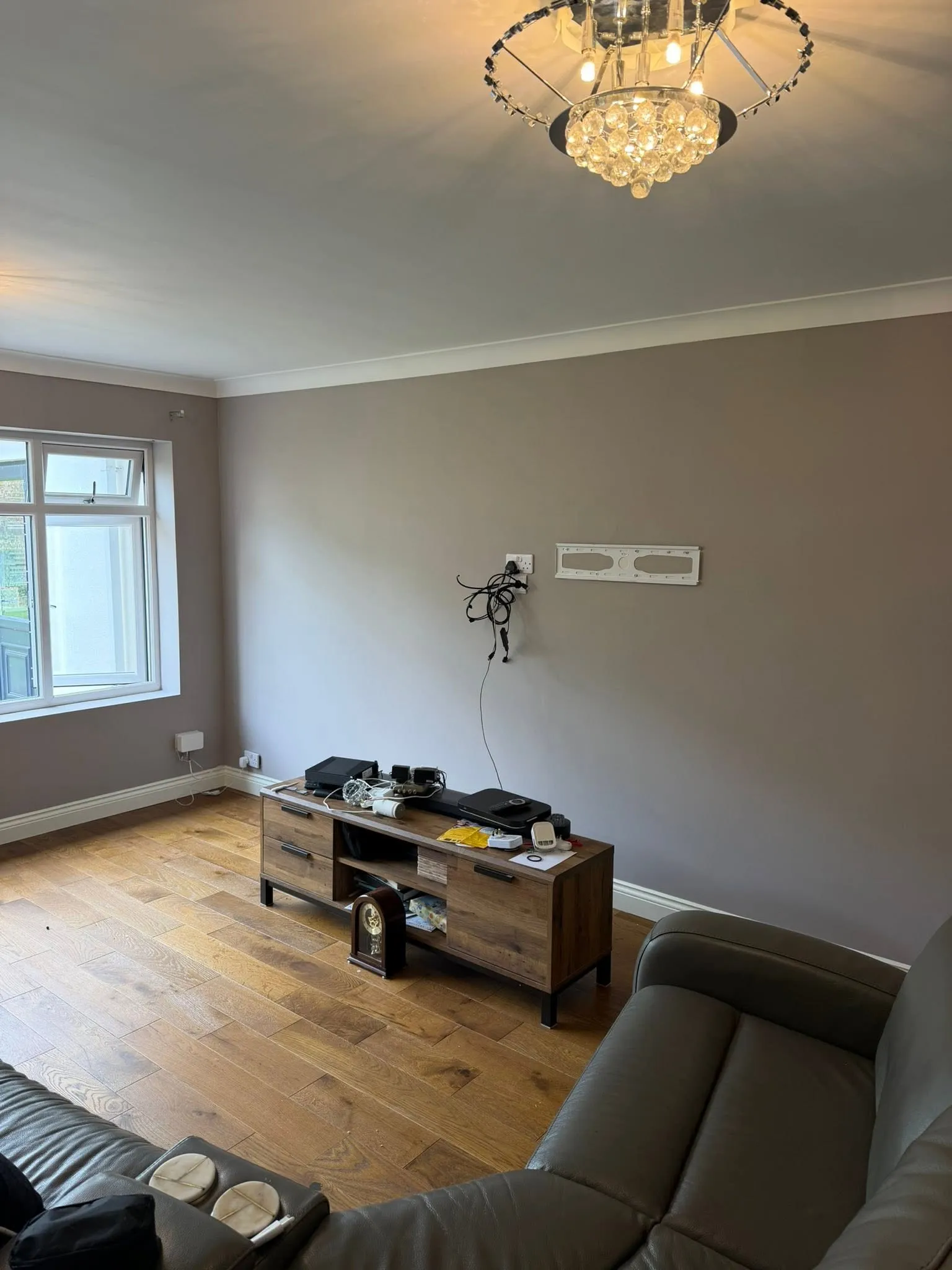The finished living room painted warm grey with white coving and a wooden floor