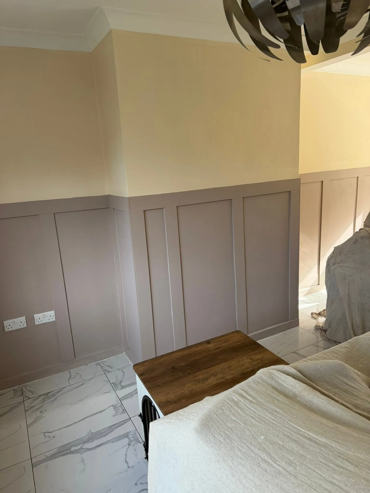 The finished bedroom panelling painted mauve below a cream wall and white coving
